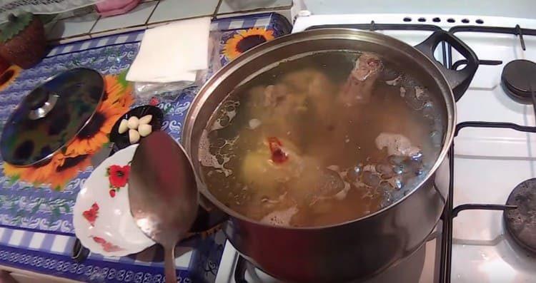 Ajouter l'oignon, le sel, le poivre et la feuille de laurier au bouillon.