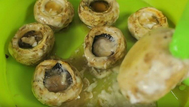 À partir des chapeaux de champignons cuits, versez le liquide formé lors de la cuisson.