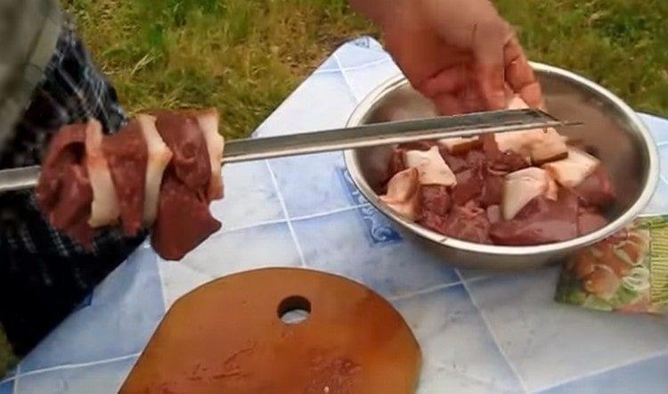 Enfiler alternativement sur une brochette des tranches de salade et de foie.