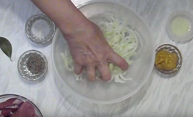 Nous coupons l'oignon en demi-anneaux et malaxons avec nos mains.