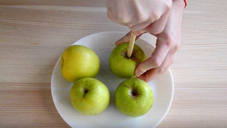 Insert a wooden stick into each apple.