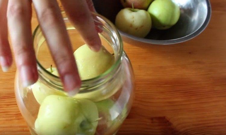 Fill sterilized jars to the top with thoroughly washed apples.