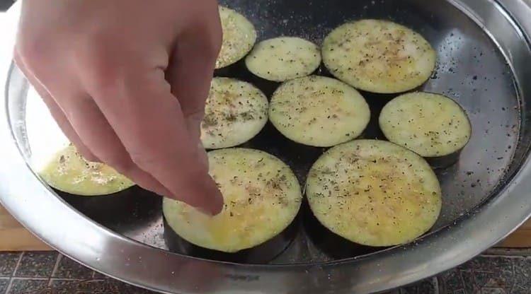 Salt, pepper eggplant circles, sprinkle with marjoram.