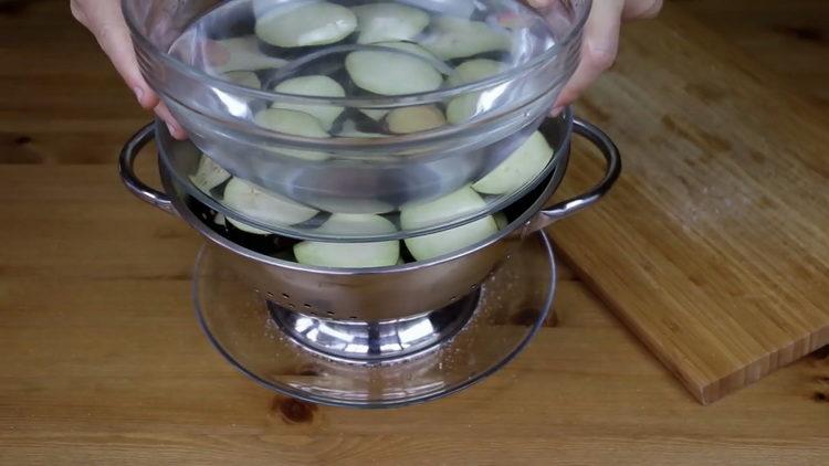 Para cocinar, coloque la berenjena debajo de la prensa.