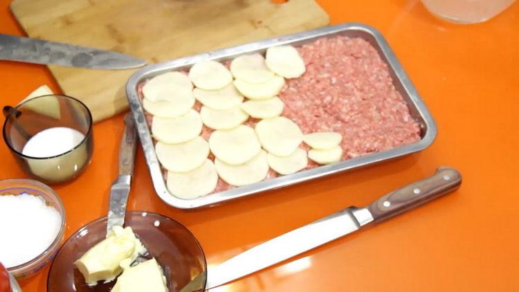 Mettez les pommes de terre sur la viande hachée pour préparer le repas.