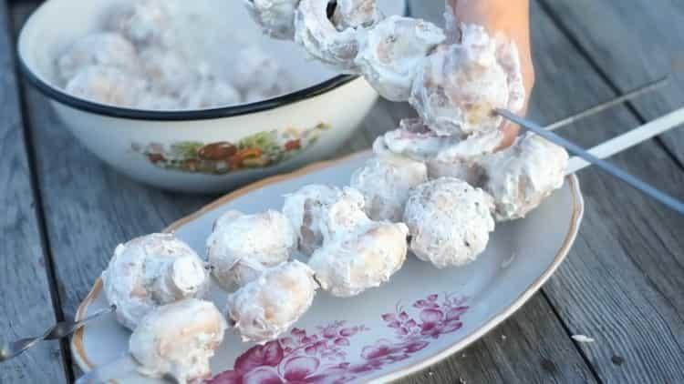 Ensarta los champiñones para cocinar