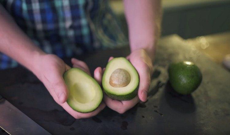 Cut the avocado in half and remove the stone.