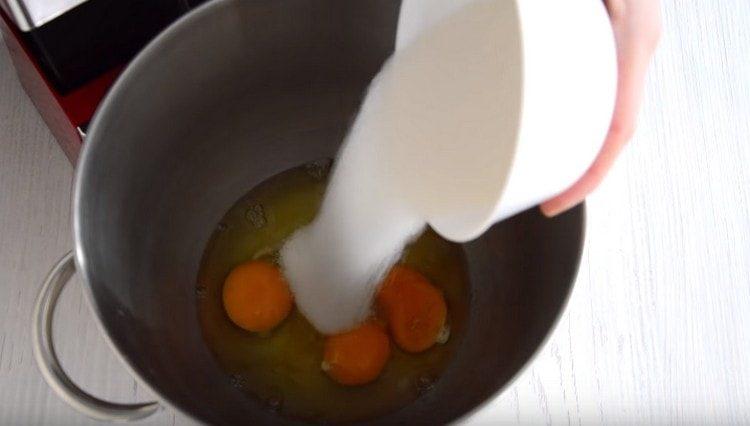 Dans le bol du batteur, battez les œufs et ajoutez du sucre.