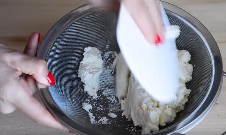 Pour préparer la crème, broyer le fromage cottage à l'aide d'une passoire.