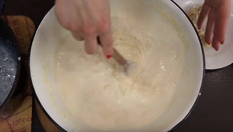 We gradually introduce milk into the dough and mix.