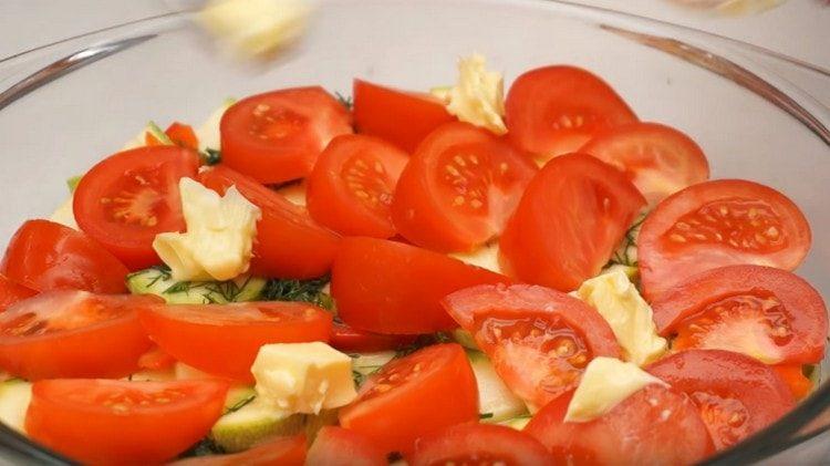 Sur le plat, étalez des tranches de tomates et des morceaux de beurre.