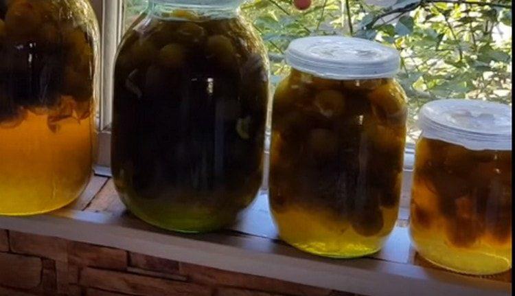 Pour jam from white plum into jars and close the lids.