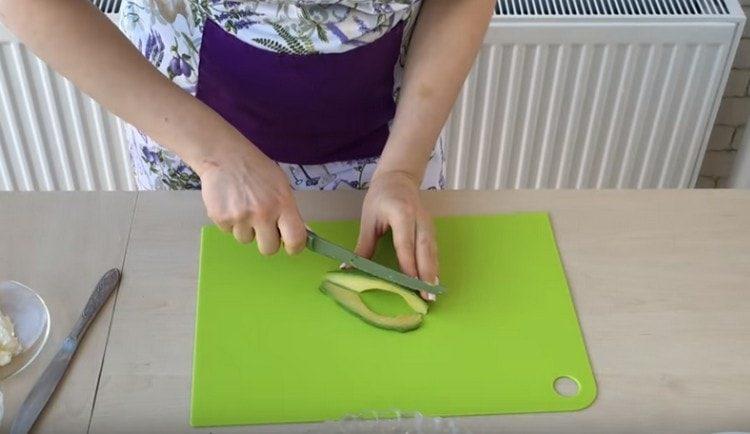 We cut avocado into thin slices.