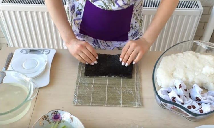 Turn the nori over and shift it to the very edge of the mat.