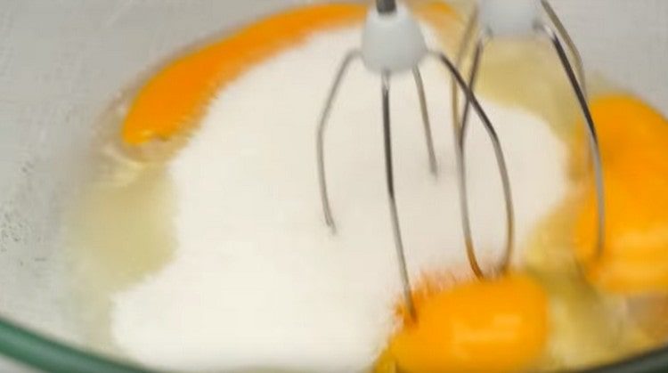 Battez les œufs avec du sucre à l'aide d'un mixeur.