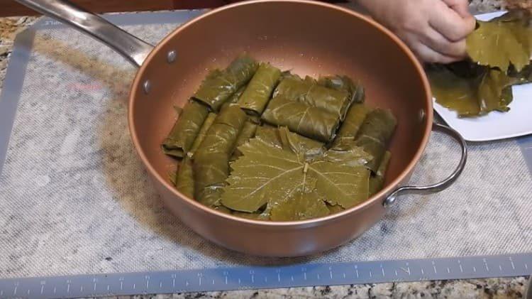 ponga la dolma en una cacerola, cubra con hojas de arriba.