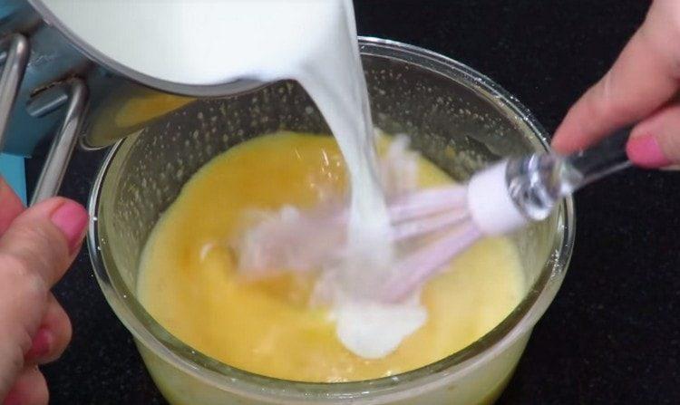 Parte de la leche caliente se introduce en la masa de huevo.