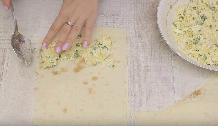 Pon el relleno en la mitad de cada cuadrado de pan de pita