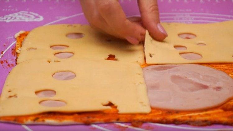 Na vrh kobasice položimo tanjure sira.