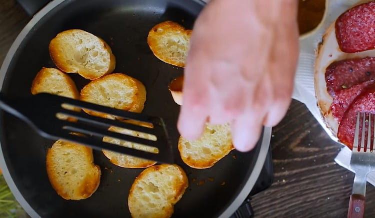 Freír las rebanadas de baguette francés en una sartén.