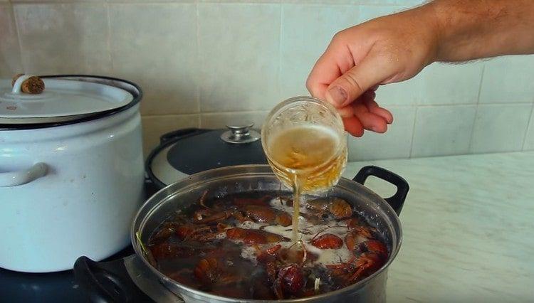 Después de poner todos los cangrejos de río, agregue cerveza a la sartén.