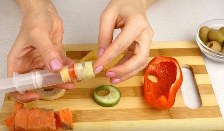 Squeeze out circles of pepper, bread and cucumber with a syringe.
