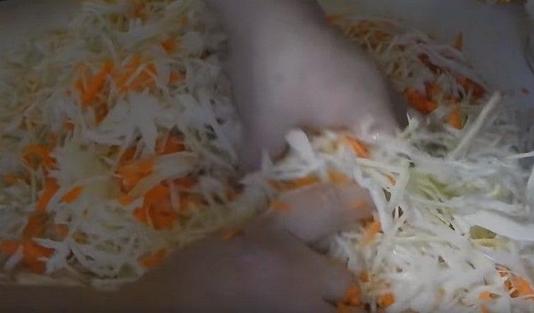 We mix cabbage with carrots and knead by hands.