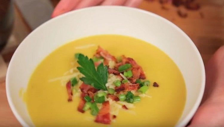 Serve the classic pumpkin soup puree, decorating it with bacon and green onions.