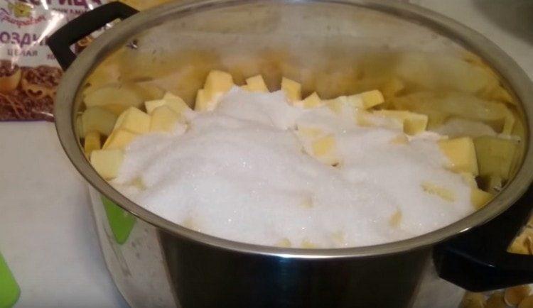 On étale les morceaux de citrouille dans une casserole, on ajoute du sucre.