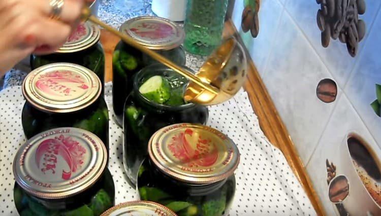 Pour jars with cucumbers with boiling water.