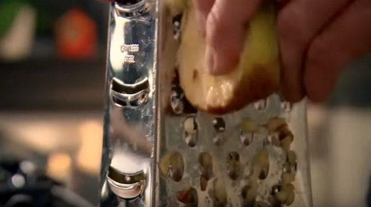 Three apples with a peel on a grater.