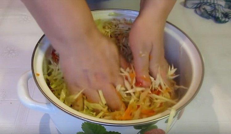 Pomiješajte kupus s povrćem, solju i začinima.