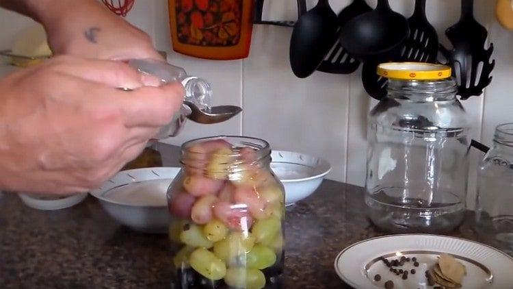 Add vinegar to the jar of grapes.