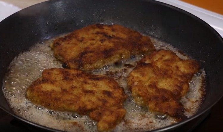 Fry pork chops sa isang kawali sa magkabilang panig.