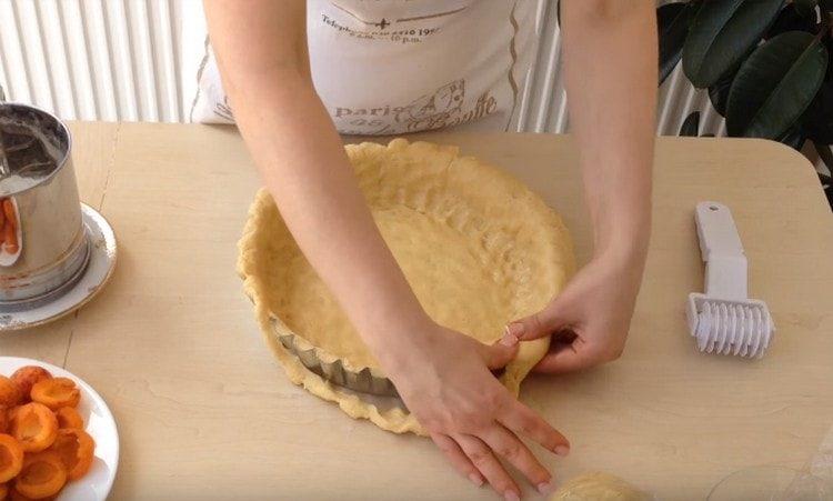 De la majeure partie de la pâte, nous formons le fond et les côtés de la tarte.