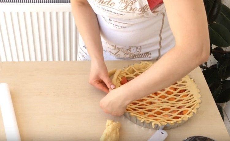 Sur le côté de la tarte, nous faisons une décoration à partir d'un flagelle de pâte.