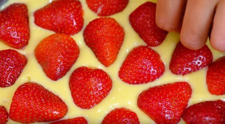 The top of the cake is decorated with halves of strawberries.