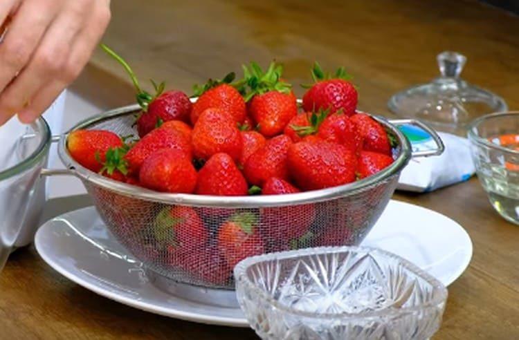Nous lavons les fraises et les laissons dans une passoire pour rendre le verre d’eau.