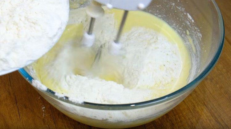 Pour flour into the dough in parts.