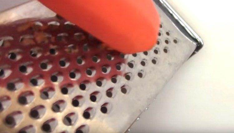 Three carrots on a grater.