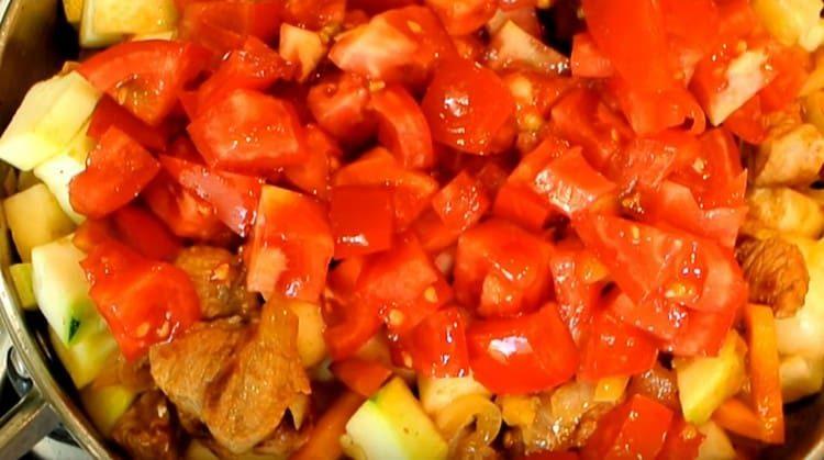 Agregue los tomates en rodajas al estofado.
