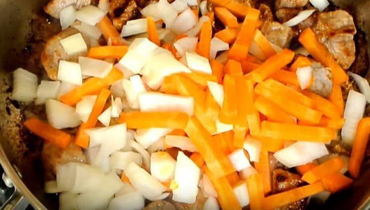 Agregue zanahorias y cebollas a la carne.