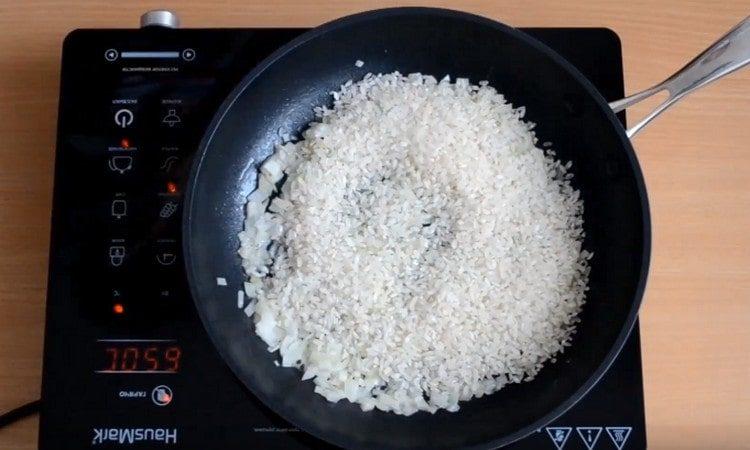 Vierte arroz en la sartén.