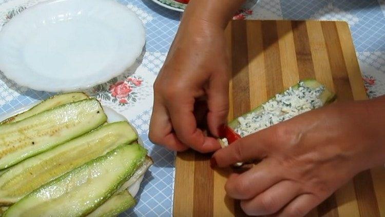 Lubrifiez les courgettes avec la garniture, étalez la tranche de tomate.