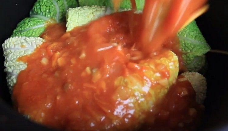 Extienda los rollos de repollo en una sartén o olla de cocción lenta, vierta la fritura de tomate.