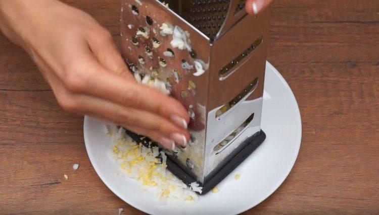 three boiled eggs on a grater.