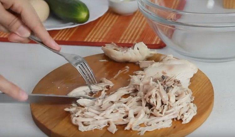 We divide the boiled chicken fillet into fibers.