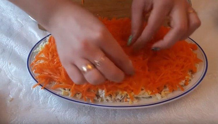 hacher finement les carottes coréennes et en former une autre couche de salade.