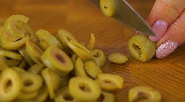 Cut the olives into rings.