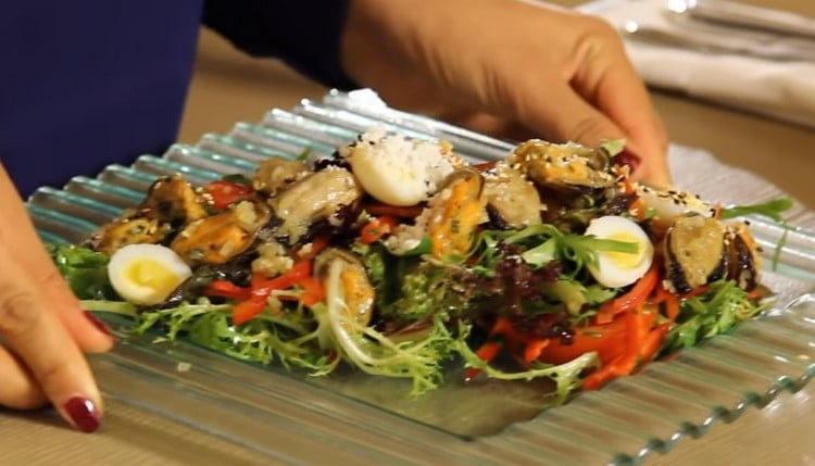 Sprinkle the finished salad with mussels with sesame seeds.
